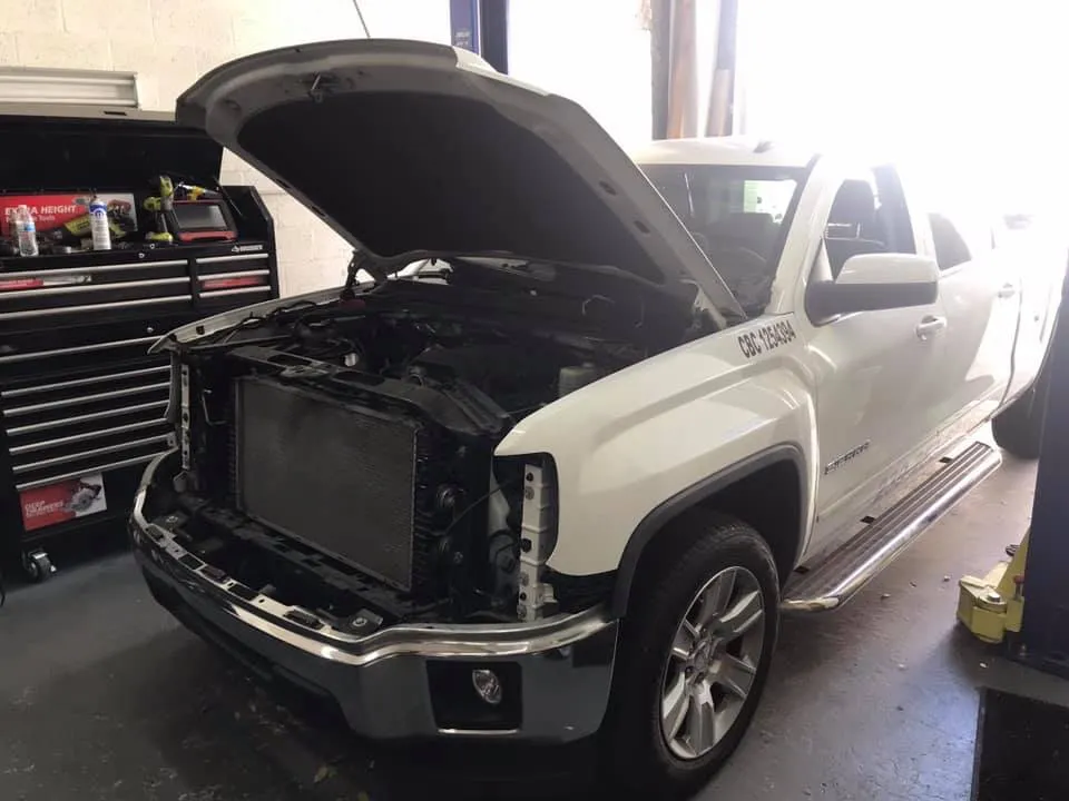 A white GMC pickup with its hood up